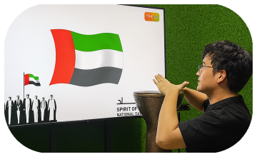 Guest playing Drum-to-Reveal interactive game at a Dubai event, beating the drum to reveal a hidden image on a large screen, designed for exhibitions and activations.